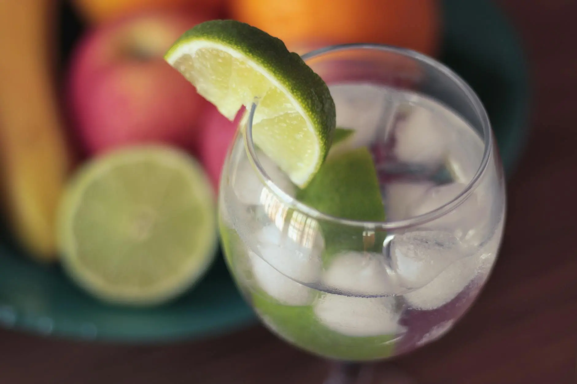 A delicious cocktail with ice and lime slices, perfect for summer gatherings.